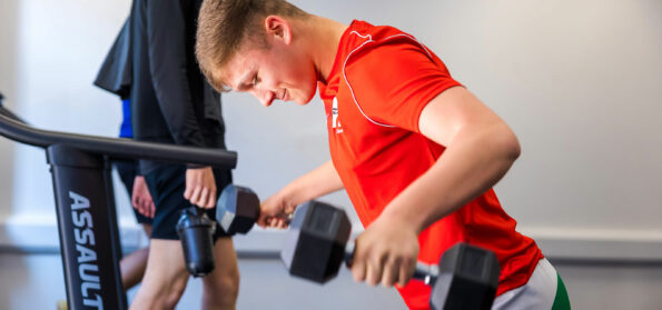 A football student training in one of our work class strength and conditioning gyms.