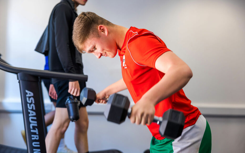 A football student training in one of our work class strength and conditioning gyms.